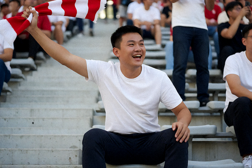 足球比赛现场球迷在看台上挥舞围巾庆祝进球